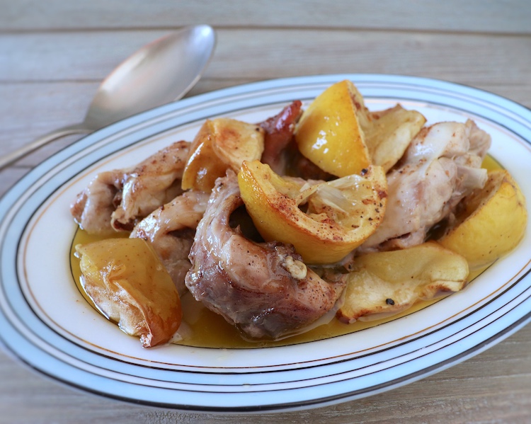 Rabbit in the oven with apple and lemon on a platter