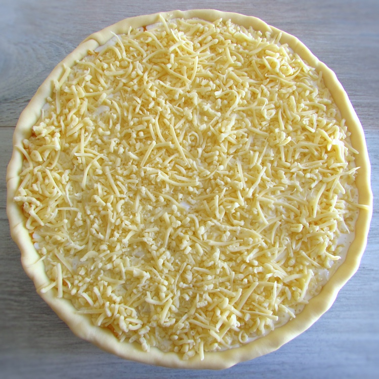 Pie filled with tuna mixture and sprinkled with grated cheese
