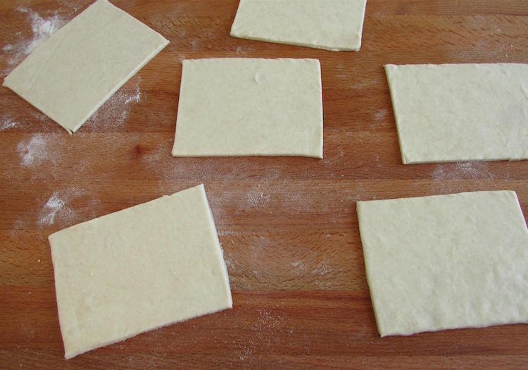 Puff pastry cut into rectangles on a table