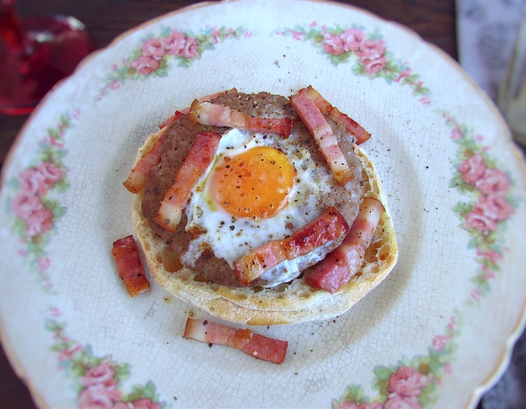 Burgers with egg and bacon on a plate