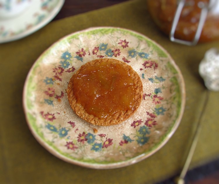 A cracker with fig jam on a small plate