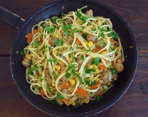 Spaghetti with tuna, corn and mushrooms on a frying pan