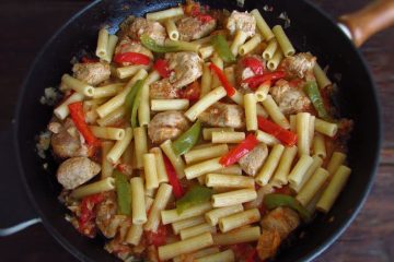 Pasta with pork and peppers on a frying pan