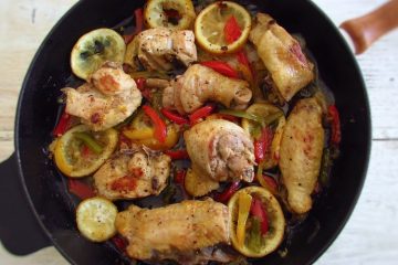 Fried chicken with peppers and lemon on a frying pan
