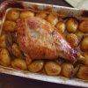 Roasted turkey leg with potatoes on a baking dish