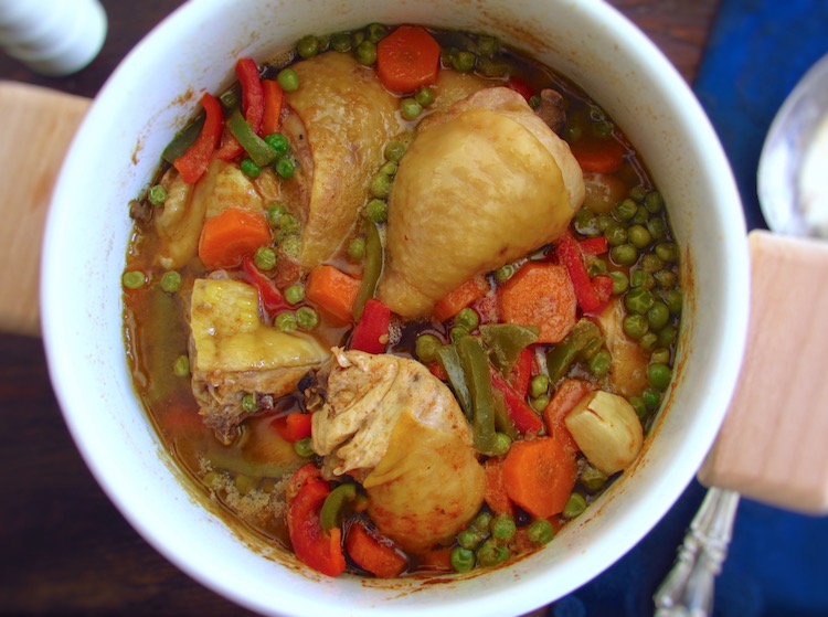 Chicken stew with peas, carrot and peppers in a pot