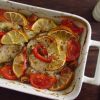 Baked hake with tomato and lemon on a baking dish