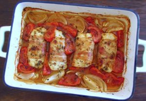 Hake loins with bacon on a baking dish
