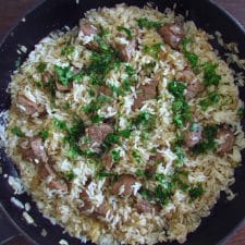 Fried veal with rice on a frying pan