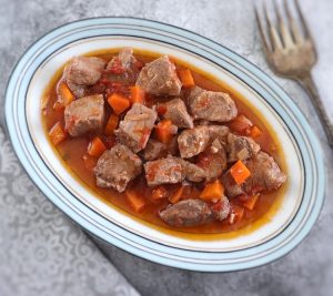 Pork stew with carrot on a platter