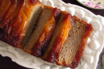 Banana cake with caramelized pear slices on a platter