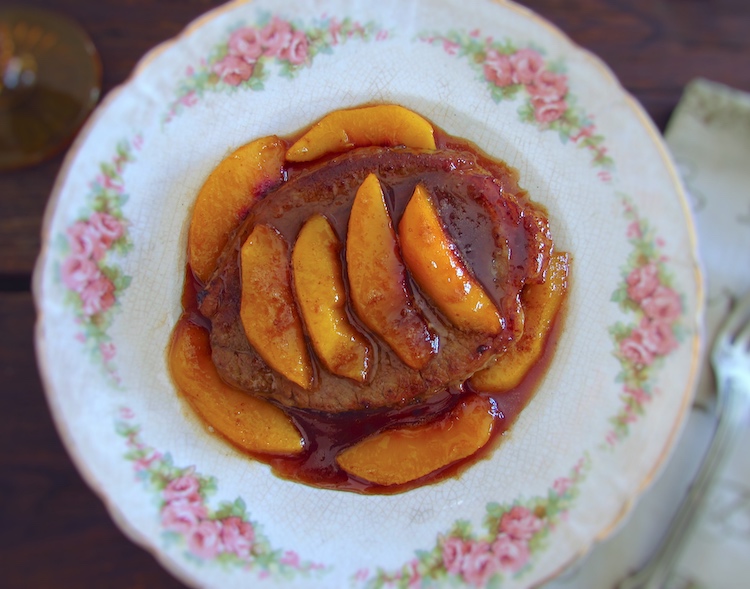 Beef medallions with caramelized peach on a plate