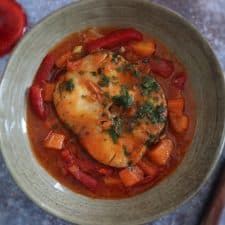 Simple fish stew with carrot and red pepper on a dish bowl