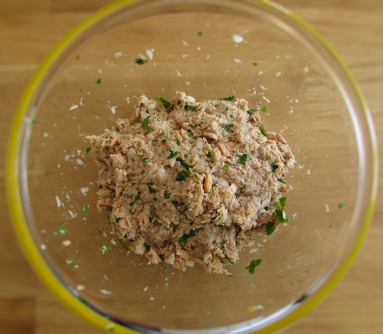 Tuna mixed with chopped onion, egg yolk, chopped coriander, a pinch of salt, pepper and the breadcrumbs in a glass bowl