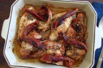 Roasted rabbit with ham on a baking dish