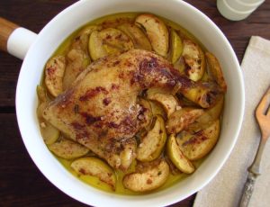 Roasted chicken legs with apple on a dish