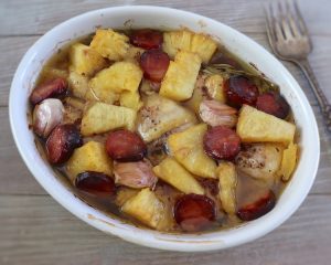 Baked chicken with chouriço and pineapple on a baking dish