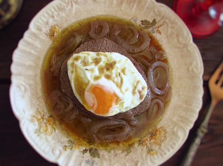 Medalhões de vaca estufados com ovo estrelado num prato