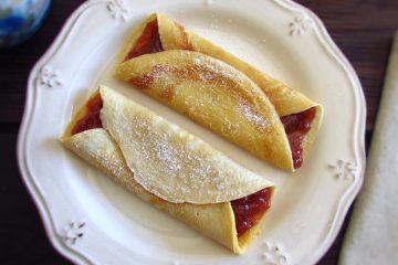 Crepes filled with strawberry jam on a plate