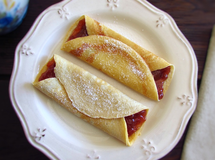 Crepes filled with strawberry jam on a plate