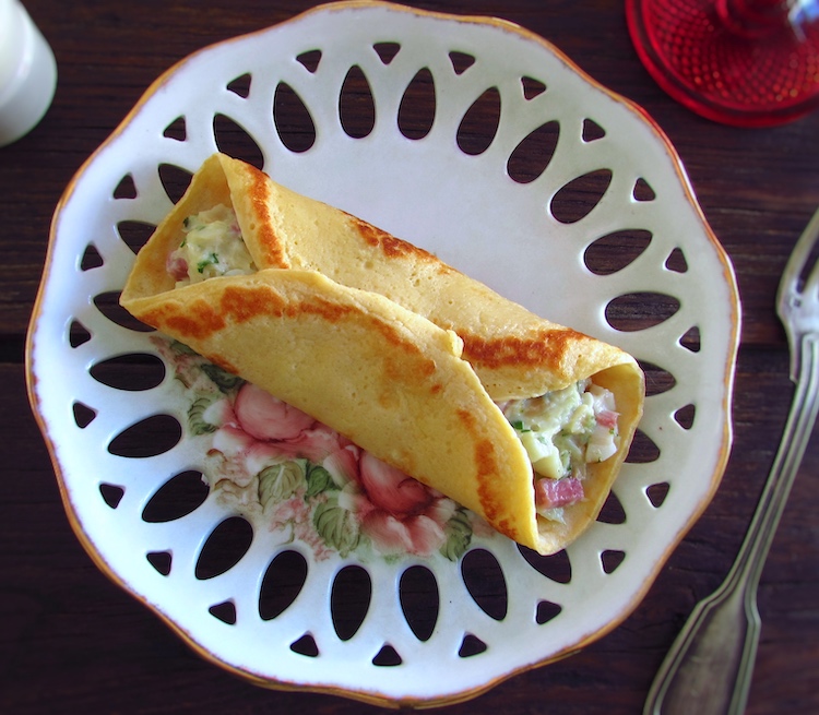 Crepes filled with cod and bacon on a plate