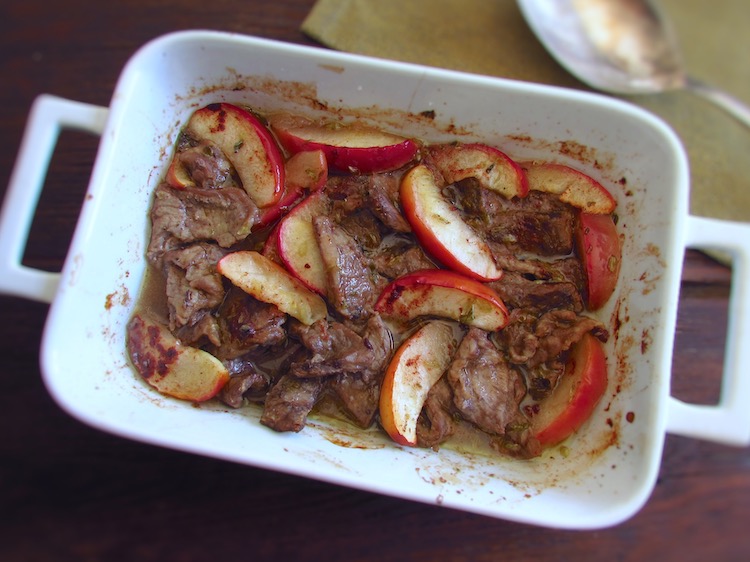 Steaks with apple in the oven on a baking dish