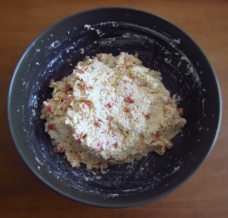 Chopped chicken, chouriço cut into pieces, peeled garlic and nutmeg mixed with mayonnaise and grated cheese in a bowl