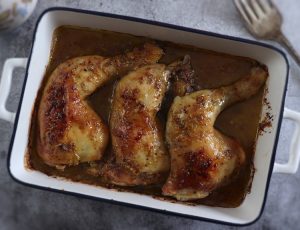 Roasted chicken legs with mustard on a baking dish
