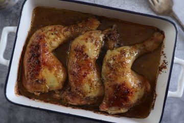 Roasted chicken legs with mustard on a baking dish