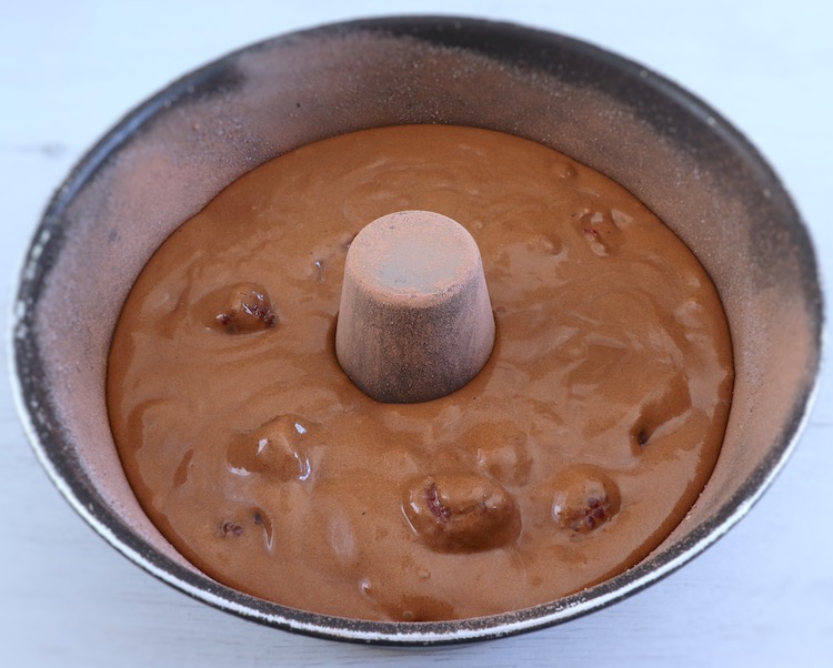 Creme de bolo de chocolate e framboesa numa forma de bolos redonda com furo no meio
