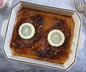 Roasted pork chops with lemon on a baking dish