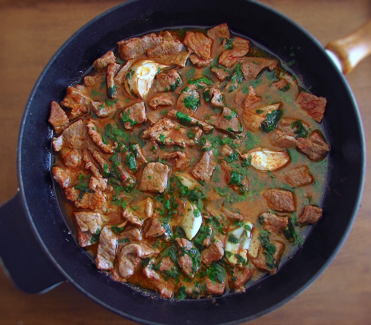 Beef steaks with fries on a frying pan