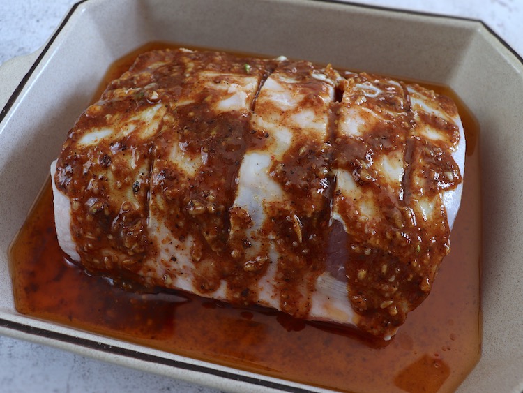 Homemade pork loin seasoned with spices on a baking dish