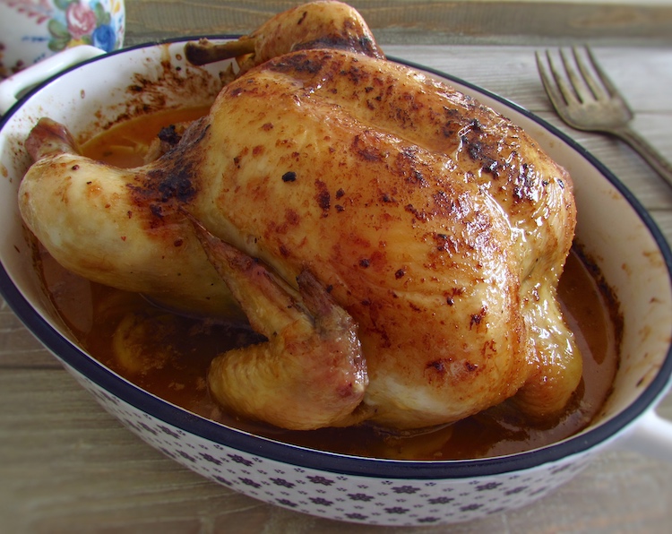 Frango simples no forno com limão numa assadeira com um garfo