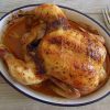 Simple roasted chicken with lemon on a baking dish with a fork