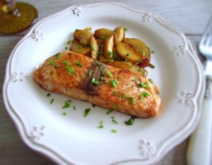 Salmon with caramelized apple on a plate with a fork