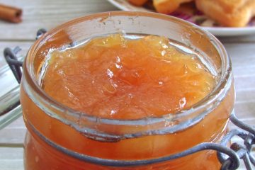Pear honey jam in a glass jar with toasts and cinnamon stick