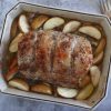 Baked pork loin with apple and rosemary on a baking dish