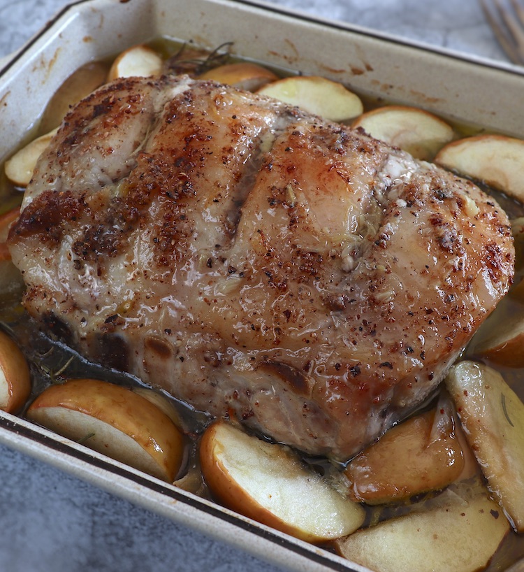 Juicy baked pork loin with apples on a baking dish