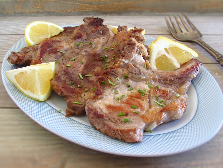 Grilled chops with lemon and rosemary on a platter
