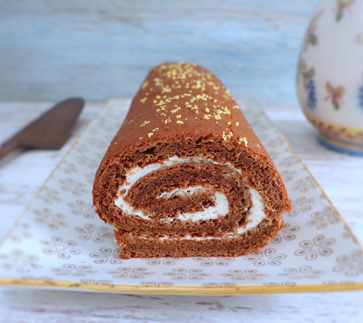 Roll cake filled with whipped cream on a rectangular plate