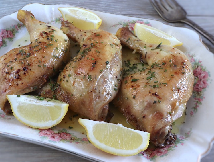 Chicken legs in the oven with garlic and lemon on a platter