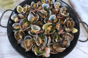 Clams with bacon and garlic on a frying pan