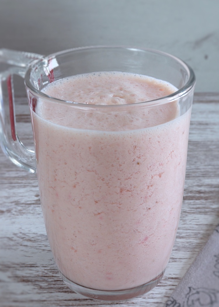 Strawberry and peach milkshake on a glass cup