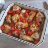 Chicken in the oven with cherry tomato and carrot on a baking dish
