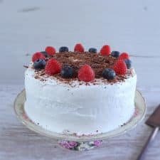 Cocoa cake with cream and berries on a plate
