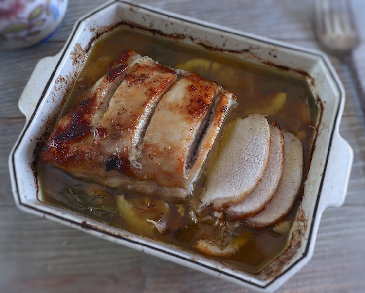 roasted pork loin with lemon and rosemary on a baking dish