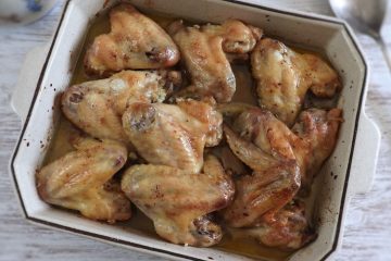 Chicken wings in the oven with olive oil and lemon on a baking dish