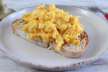 Ovos mexidos com uma fatia de pão num prato