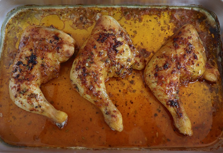 Spicy roasted chicken legs on a baking sheet